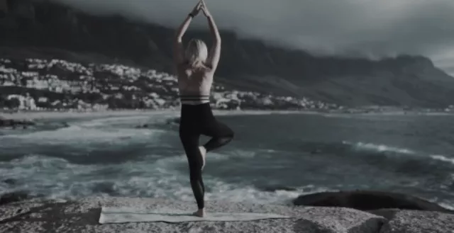 在海邊做瑜伽的年輕女性