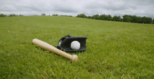 放在草地上的棒球、棒球棒和棒球手套